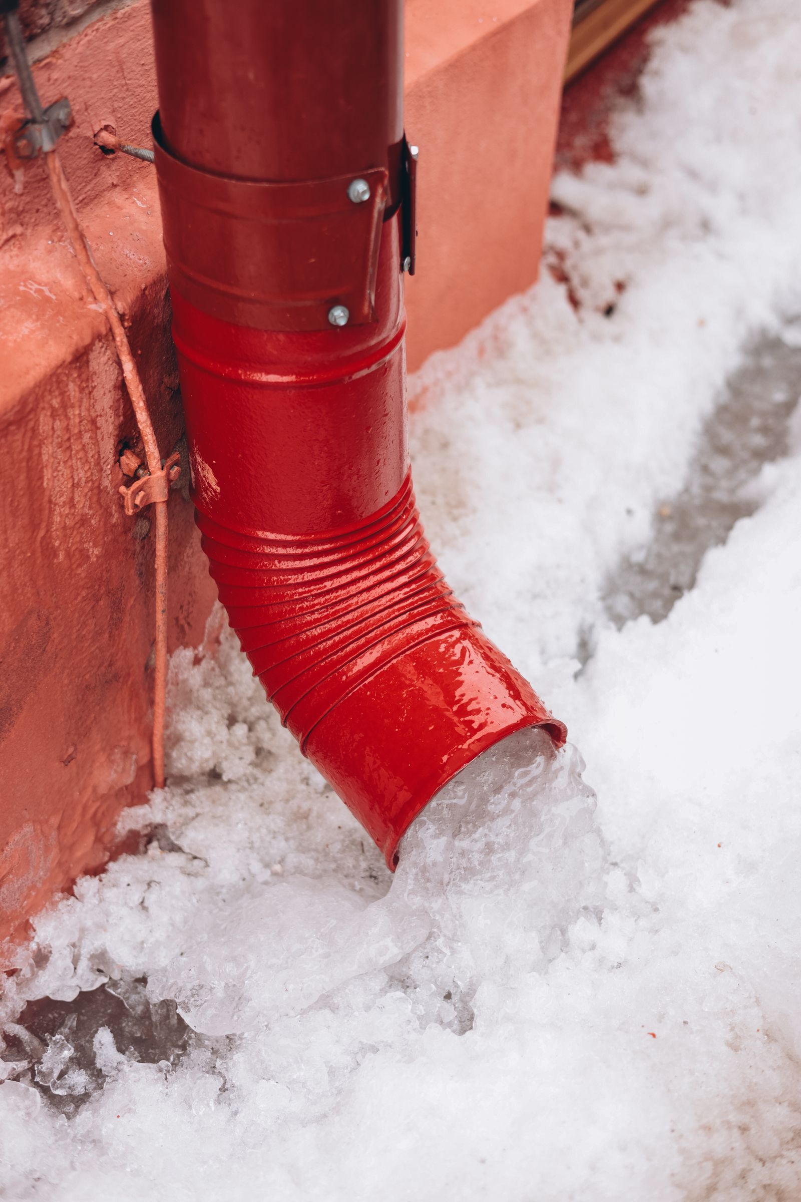 Melting snow beside a house foundation